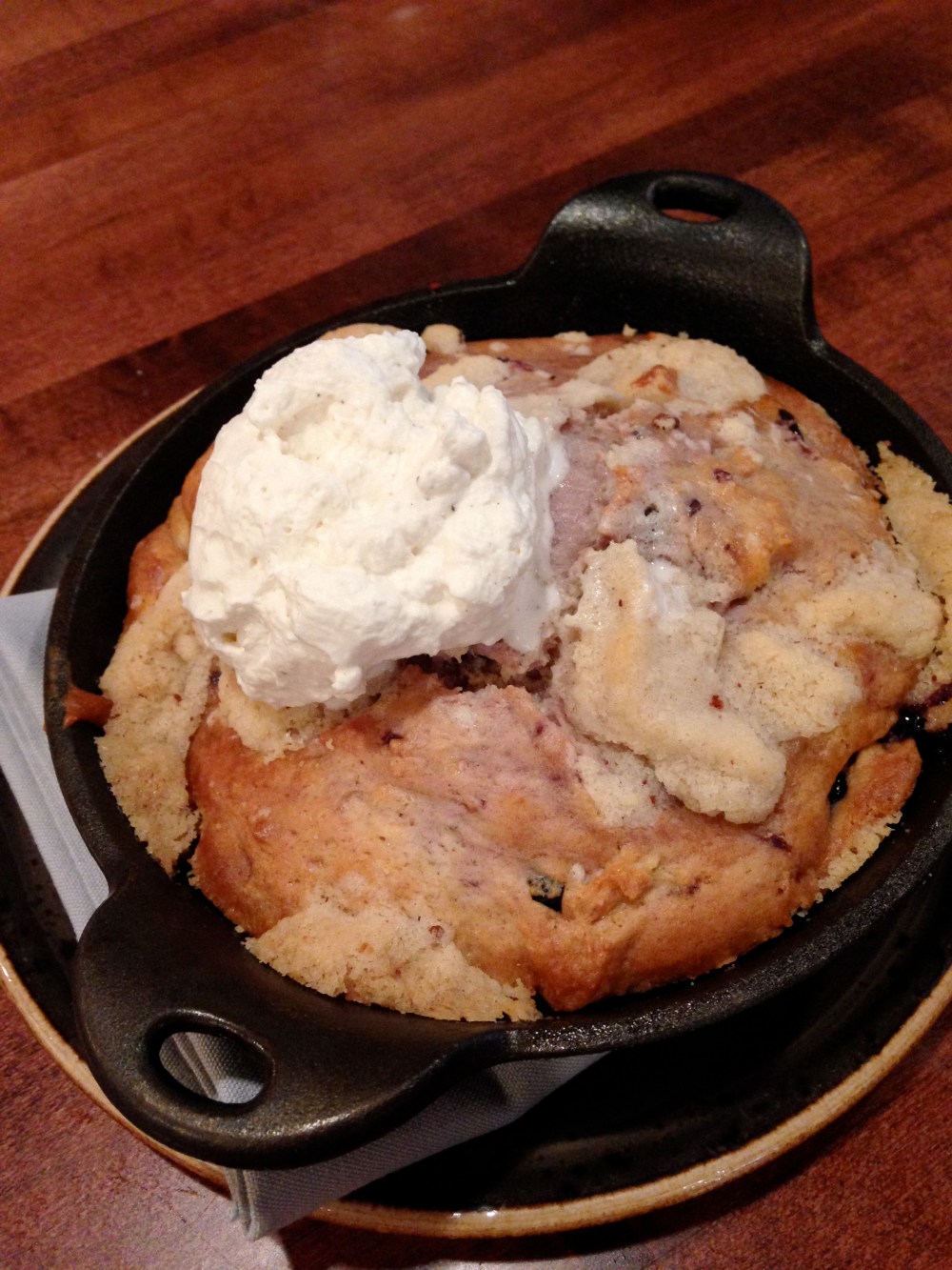 Ellen's Berry Buckle cooked in a cast iron pan creates the perfect ratio of caramelized crust and rich soft middle.  Topped with cream you